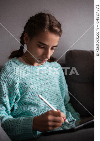 Young teenage girl drawing on tablet PC with pen Young teenage girl drawing on tablet PC with pen 64827871