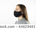 Portrait of young woman wearing black face mask isolated on gray background. Dust protection against virus. Coronavirus pandemic time. Female looking at camera 64829483