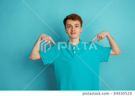 Caucasian young man's monochrome portrait on blue studio background, emotinal and beautiful Caucasian young man's monochrome portrait on blue studio background, emotinal and beautiful 64830529