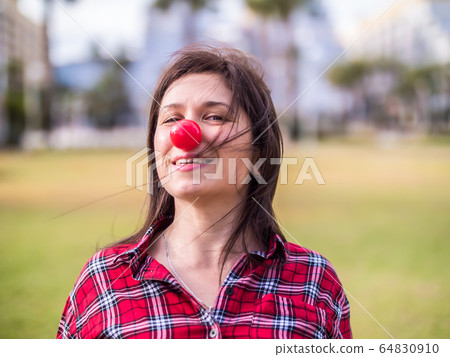 happy young girl with a clown nose. Joke, humor and funny portrait concept. April fools day happy young girl with a clown nose. Joke, humor and funny portrait concept. April fools day 64830910