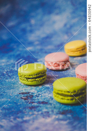 Variety of colorful macarons over a blue Variety of colorful macarons over a blue 64830942