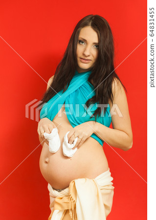 Adult woman showing her pregnant belly Adult woman showing her pregnant belly 64831455