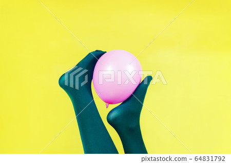 Green legs of a woman holding a pink balloon Green legs of a woman holding a pink balloon 64831792