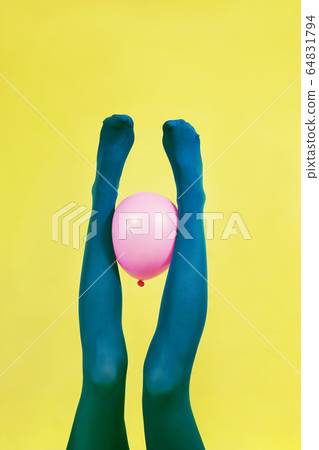 Green legs of a woman holding a pink balloon Green legs of a woman holding a pink balloon 64831794