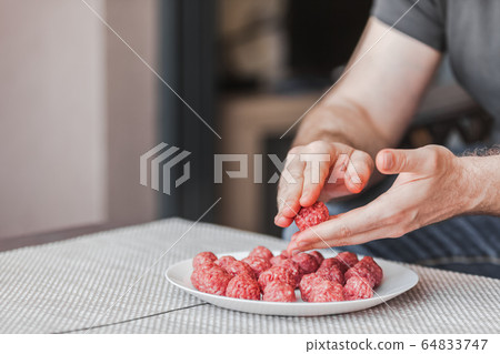 Man hands preparing meatballs with raw mincemeat Man hands preparing meatballs with raw mincemeat 64833747