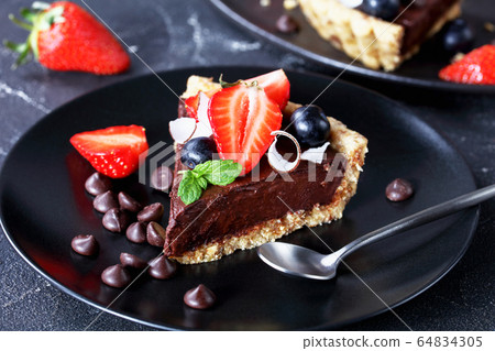 Chocolate tart with the crust of oats and dates Chocolate tart with the crust of oats and dates 64834305