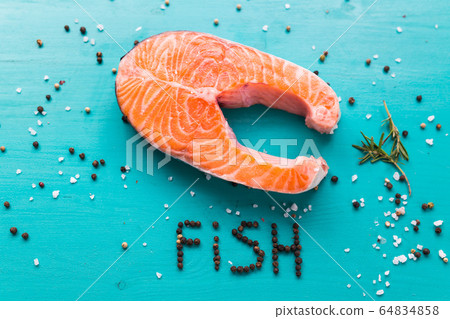Salmon with lemon, pepper and rosemary on blue background and the inscription pepper fish. Keto diet, pescetarianism and healthy food concept. Salmon with lemon, pepper and rosemary on blue background and the inscription pepper fish. Keto diet, pescetarianism and healthy food concept. 64834858
