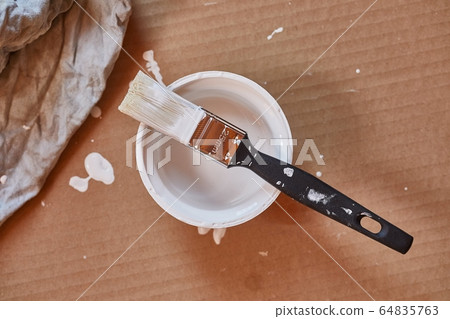 Paint brush on a can of white wall paint Paint brush on a can of white wall paint 64835763