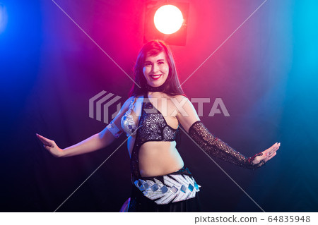 Young woman dancing in Tribal Fusion style. Belly dance on the stage. Young woman dancing in Tribal Fusion style. Belly dance on the stage. 64835948
