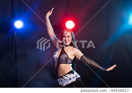 Young woman dancing in Tribal Fusion style. Belly dance on the stage. 64836017