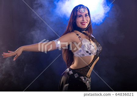 Spirituality dance. Beautiful sexy woman with luxury glossy eastern make-up dancing tribal fusion. Belly dance. Spirituality dance. Beautiful sexy woman with luxury glossy eastern make-up dancing tribal fusion. Belly dance. 64836021