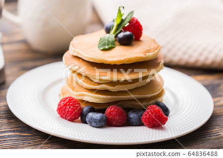 Homemade american pancakes with fresh blueberry and raspberries. Healthy morning breakfast. Rustic style 64836488