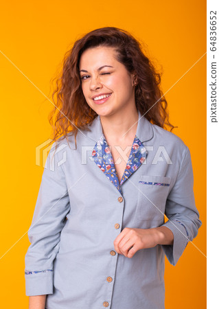 Close up portrait of lovely cute funny lady making winks having holidays dressed in comfortable clothing isolated on yellow background. Holidays, party and summer concept. Close up portrait of lovely cute funny lady making winks having holidays dressed in comfortable clothing isolated on yellow background. Holidays, party and summer concept. 64836652