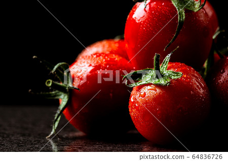 fresh tomatoes with wet and droplet on black stone fresh tomatoes with wet and droplet on black stone 64836726