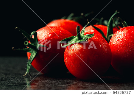 fresh tomatoes with wet and droplet on black stone fresh tomatoes with wet and droplet on black stone 64836727