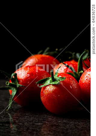 fresh tomatoes with wet and droplet on black stone fresh tomatoes with wet and droplet on black stone 64836728