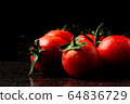fresh tomatoes with wet and droplet on black stone 64836729