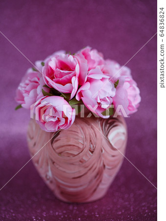 Beautiful little pink flowers in a small vase with a pattern on a dark pink shiny background 64836824