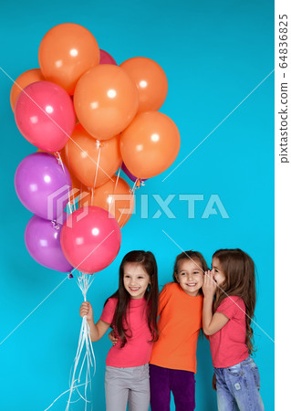 Smiling little children girls posing with bright colorful air balloons 64836825