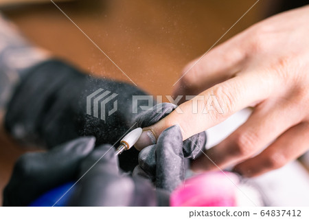 Close-up automatic electric manicure drill polish remover for nail women. Nail, gel polish and beauty salon concept. Close-up automatic electric manicure drill polish remover for nail women. Nail, gel polish and beauty salon concept. 64837412