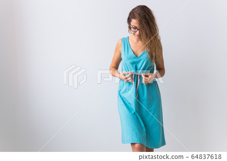 Fashion, summer and vacation concept - beautiful female model in blue dress on white background with copy space. 64837618