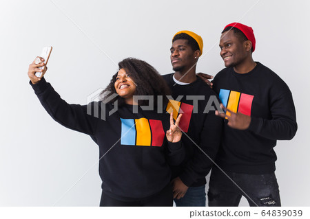Friendship and fun concept - Group of friends afro american men and woman taking selfie in studio on white background. Friendship and fun concept - Group of friends afro american men and woman taking selfie in studio on white background. 64839039