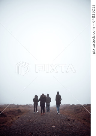 Four people hiking with fog Four people hiking with fog 64839212