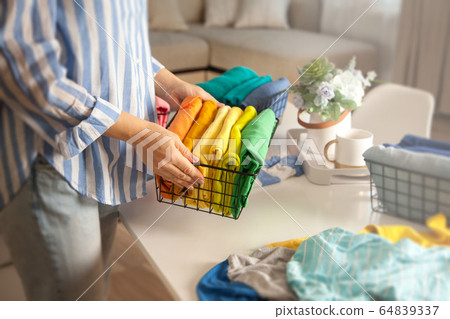 Woman in casual clothes lays clothes in metal mesh Woman in casual clothes lays clothes in metal mesh 64839337