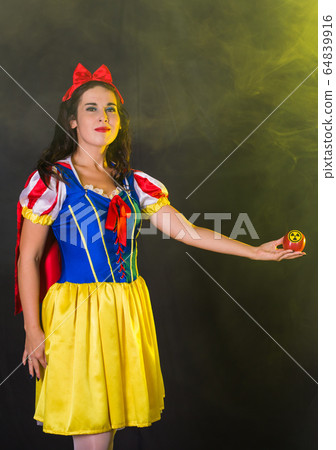 Woman dressed as fairytale character holds Radioactive atomic nuclear ionizing radiation danger warning symbol on apple. Nuclear and radiation measurement concept. Woman dressed as fairytale character holds Radioactive atomic nuclear ionizing radiation danger warning symbol on apple. Nuclear and radiation measurement concept. 64839916