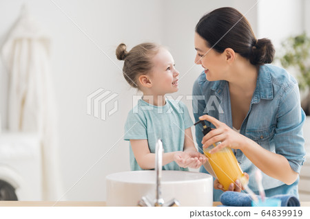 girl and her mother are washing hands girl and her mother are washing hands 64839919
