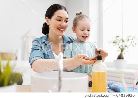girl and her mother are washing hands girl and her mother are washing hands 64839920