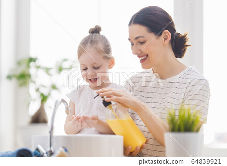 girl and her mother are washing hands girl and her mother are washing hands 64839921