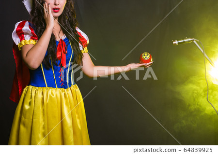 Danger, nuclear and radiation measurement - Girl holds apple with radiation hazard symbol. 64839925