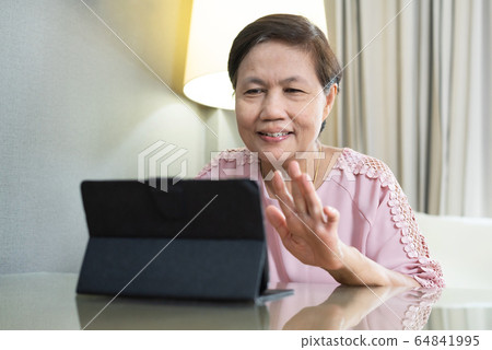 Smiling Asian Elderly woman making video call  64841995