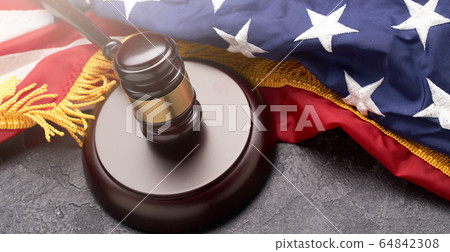 Top view of wooden gavel on background of American flag on black background 64842308