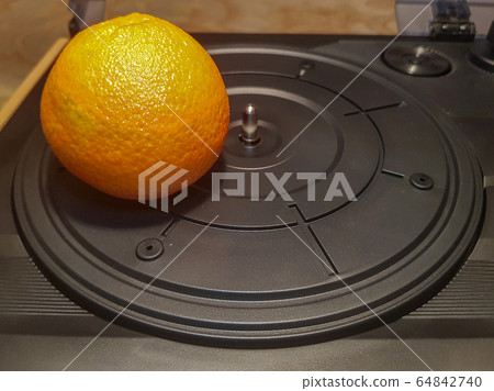 Mandarin on the turntable of record player Mandarin on the turntable of record player 64842740