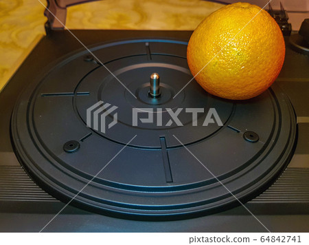 Mandarin on the turntable of record player Mandarin on the turntable of record player 64842741