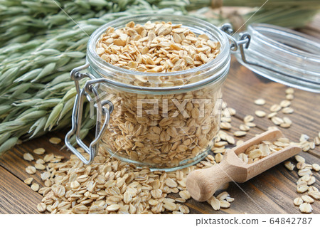 Jar of oat flakes and green oat ears. Jar of oat flakes and green oat ears. 64842787
