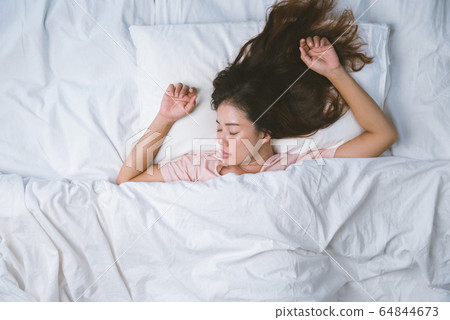 Teenage girl sleeping resting. good night sleep concept. Girl wearing a pajama sleep on a bed Teenage girl sleeping resting. good night sleep concept. Girl wearing a pajama sleep on a bed 64844673