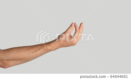 Young guy holding something on light grey background, closeup. Copy space. Panorama Young guy holding something on light grey background, closeup. Copy space. Panorama 64844681