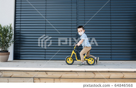 Small boy with bicycle outdoors at home. Corona virus and quarantine concept. Small boy with bicycle outdoors at home. Corona virus and quarantine concept. 64846568