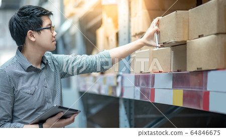 Asian man doing stocktaking by using tablet in 64846675