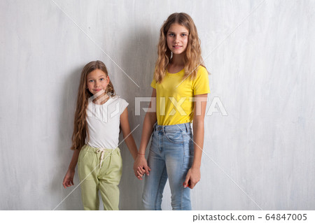 Two beautiful girls holding hands with a friend Two beautiful girls holding hands with a friend 64847005
