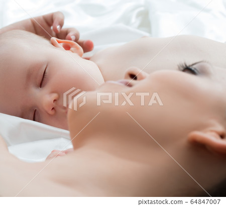 Baby boy sleeping and his mom lying on white linen Baby boy sleeping and his mom lying on white linen 64847007