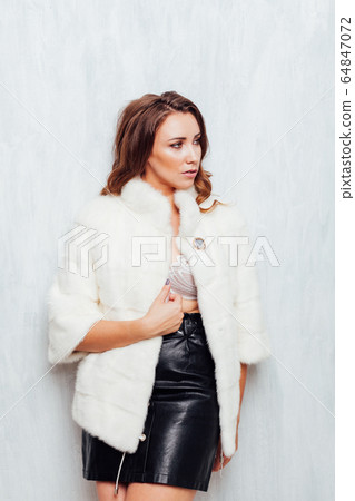 portrait of a beautiful woman with curls in a white fur coat and black skirt portrait of a beautiful woman with curls in a white fur coat and black skirt 64847072