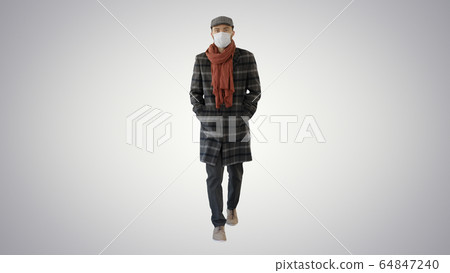 Gentleman with medical face mask walking on gradient background. 64847240