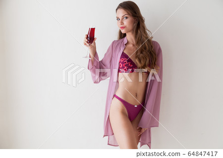 portrait of a beautiful fashionable woman in lingerie with a glass of red wine portrait of a beautiful fashionable woman in lingerie with a glass of red wine 64847417