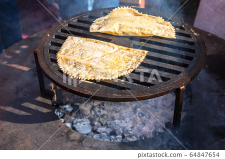 Cooking appetizing traditional uzbek pies outdoors Cooking appetizing traditional uzbek pies outdoors 64847654