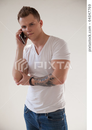 portrait of a beautiful strong fashionable man talking on a smartphone 64847769