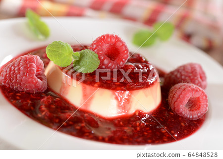 Panna cotta dessert with fresh raspberries and 64848528